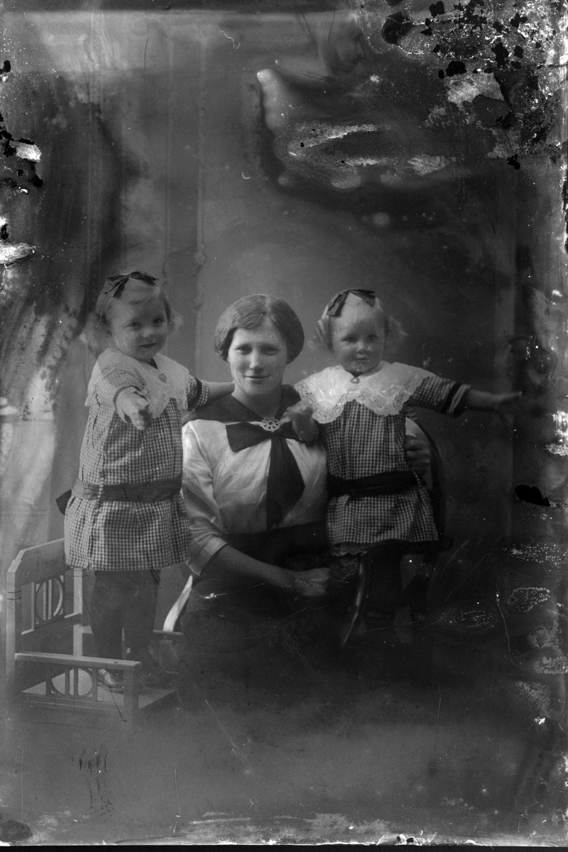 Studioportrett av en kvinne med to barn.