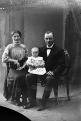 Studioportrett av en mann og kvinne med et barn.