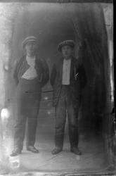 Studioportrett av to menn med sixpence-luer på hodet.