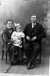 Studioportrett av familie på tre.