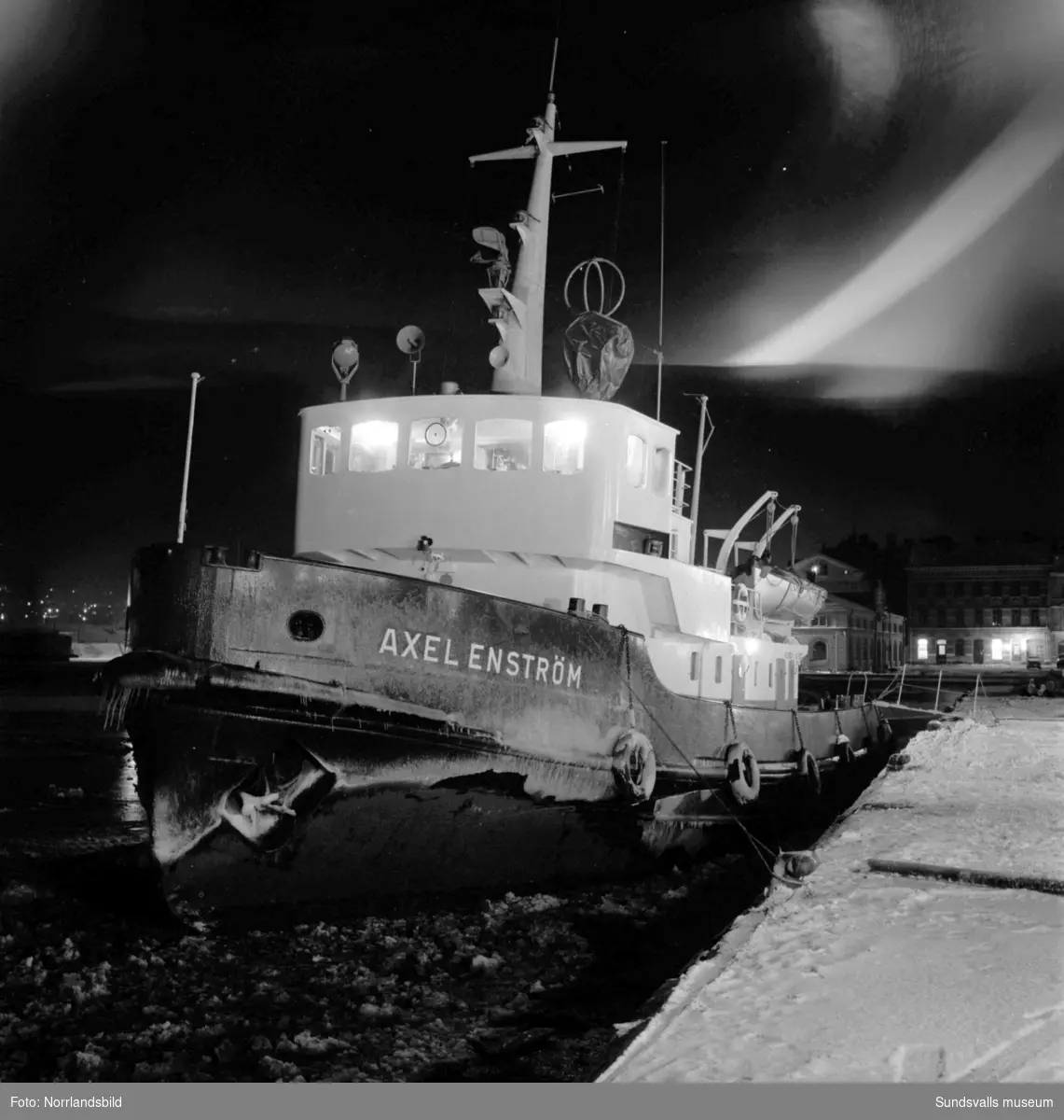 Bogserbåten och isbrytaren Axel Enström vid kaj en decemberkväll.