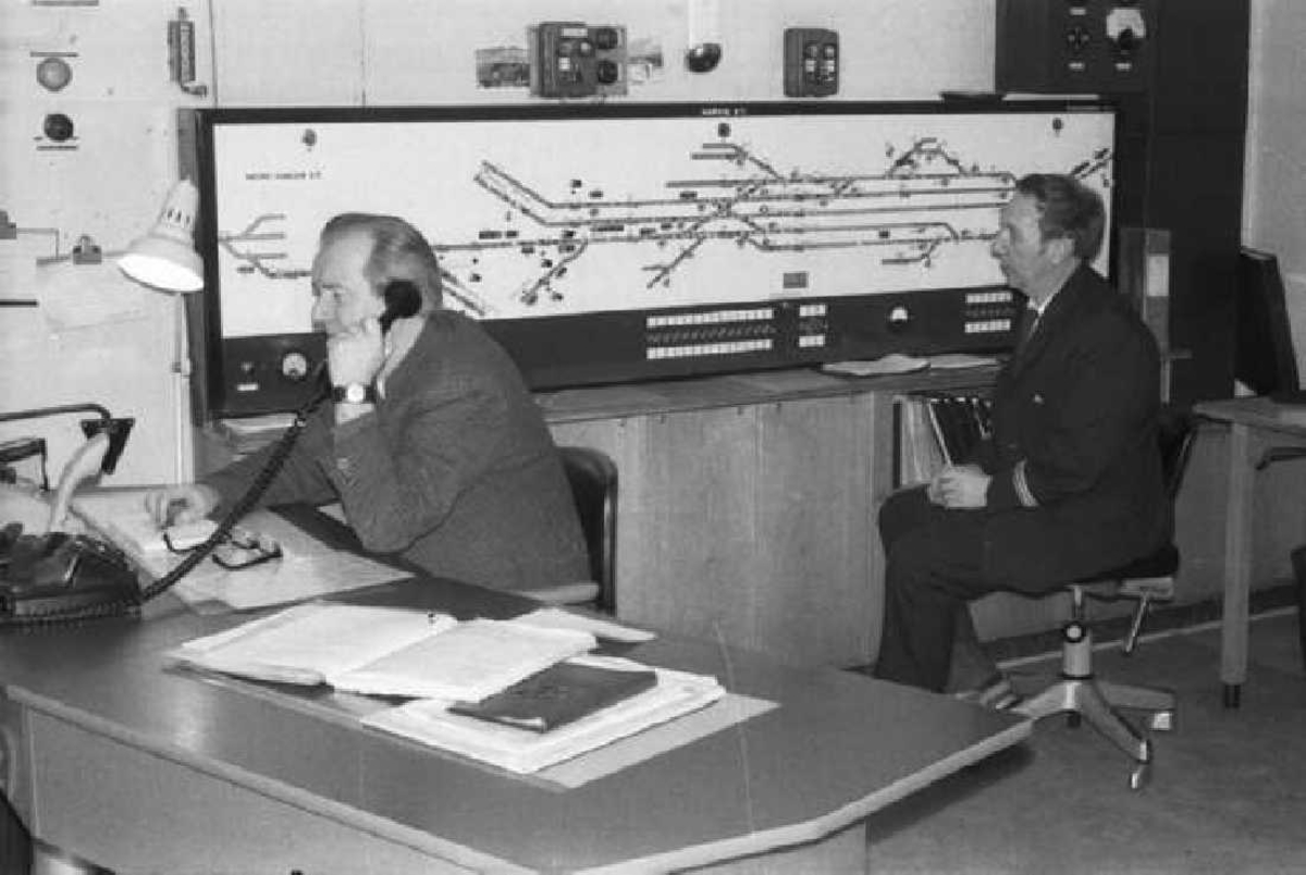 Ofotbanen ble i juli 1963 lagt om til automatisk trafikkontroll, som den første banestrekningen i landet. Her er to kontrollromoperatører i arbeid ved CTC-anlegget på Narvik stasjon. 
Vedk. til v. heter Arne Berget, til h. Ola Dahl.
