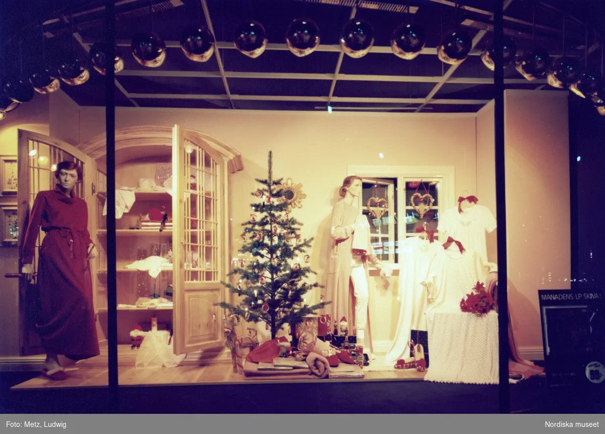 Skyltfönster på Nordiska Kompaniet. Julskyltning. Röd klänning, vita nattlinnen, morgontofflor och juldekorationer.