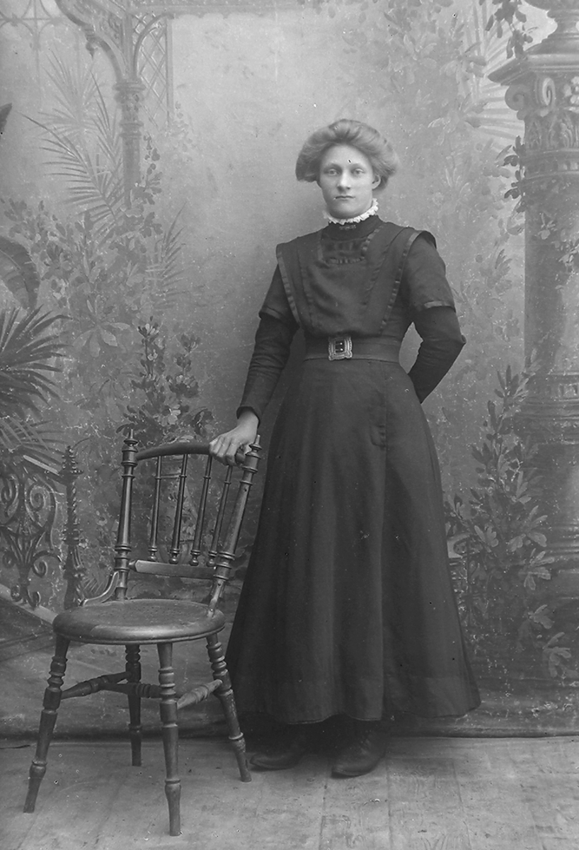 Portrett. Kvinne, ca. 20 år. Mørk, sid kjole. Høy hals med hvit rysjekant.Kathinka Hardine Olsen, f. 1895, Horseide.