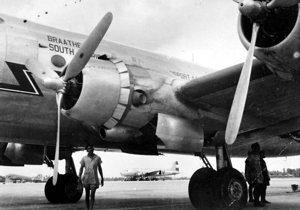Lufthavn. 1 fly på bakken Douglas DC-4 C-54 Skymaster fra Braathens SAFE. 2 personer ved flyet