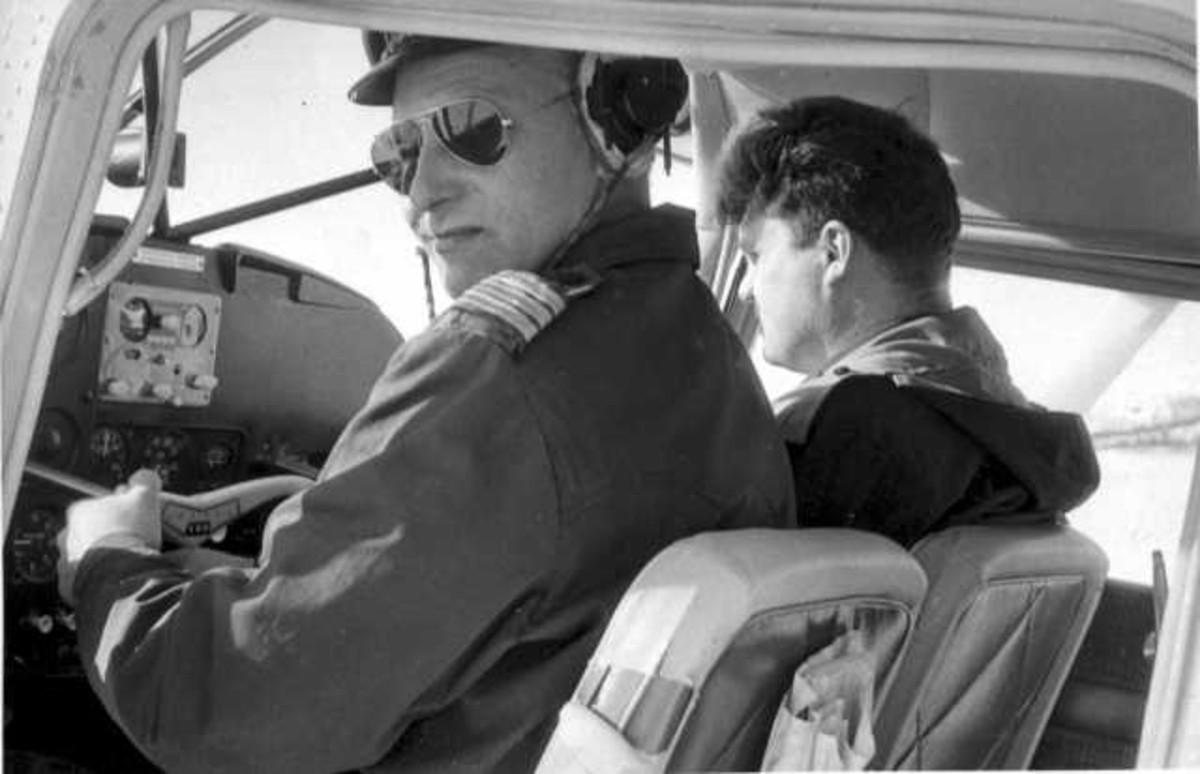 To personer, menn, i cockpiten på et fly fra Varangerfly.