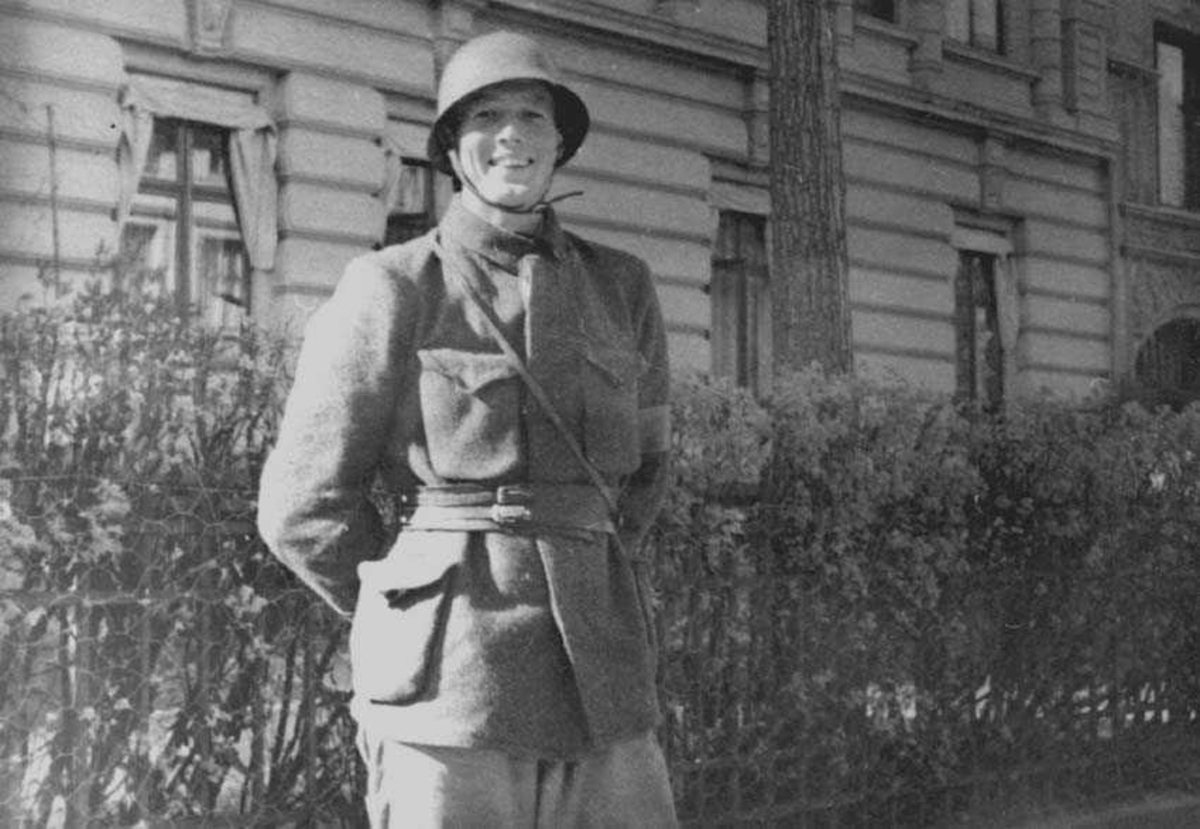En person i uniform og hjelm, som står vakt utenfor en bygning.