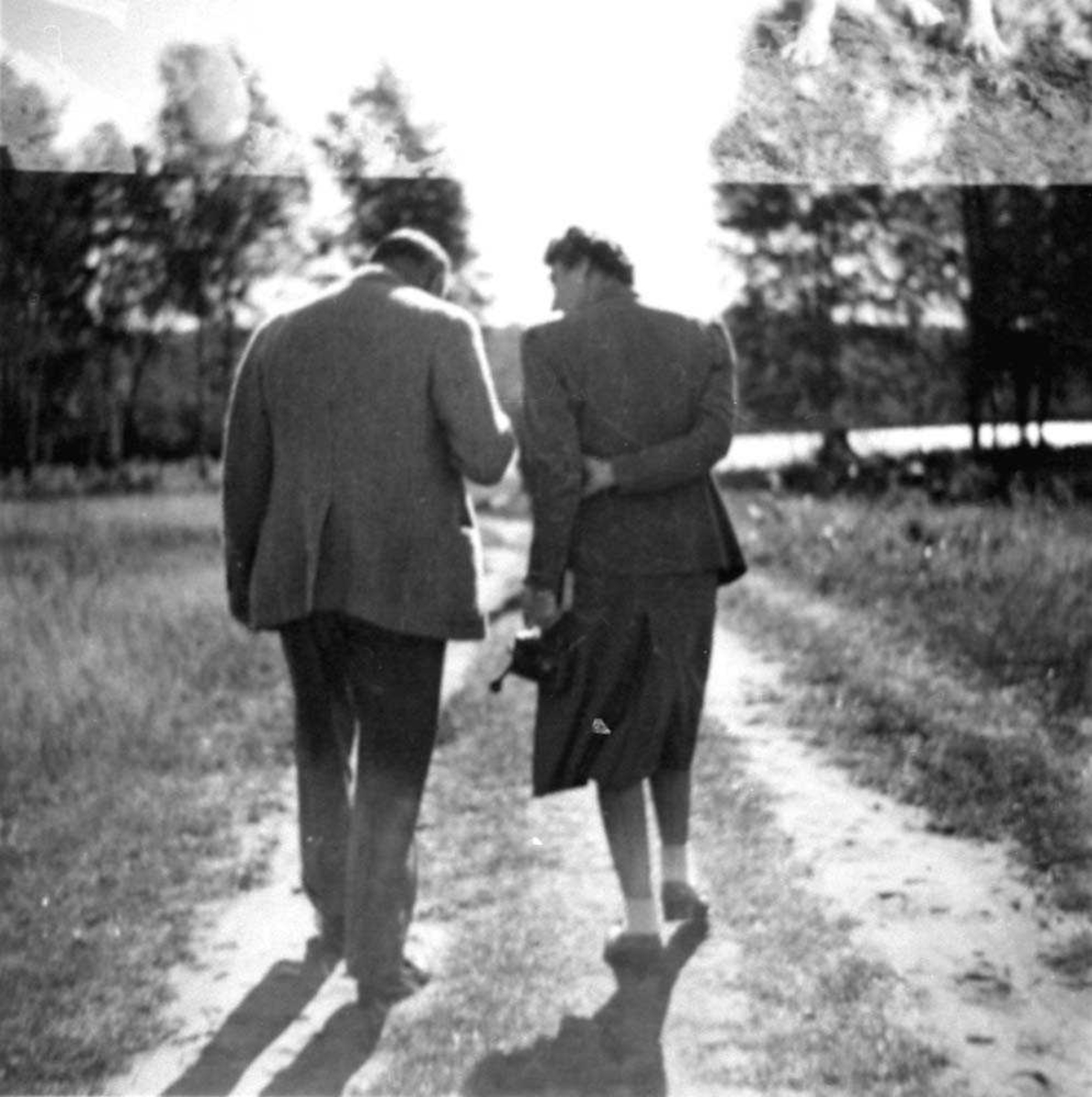 Portrett. To personer, mann og kvinne som går på en vei.