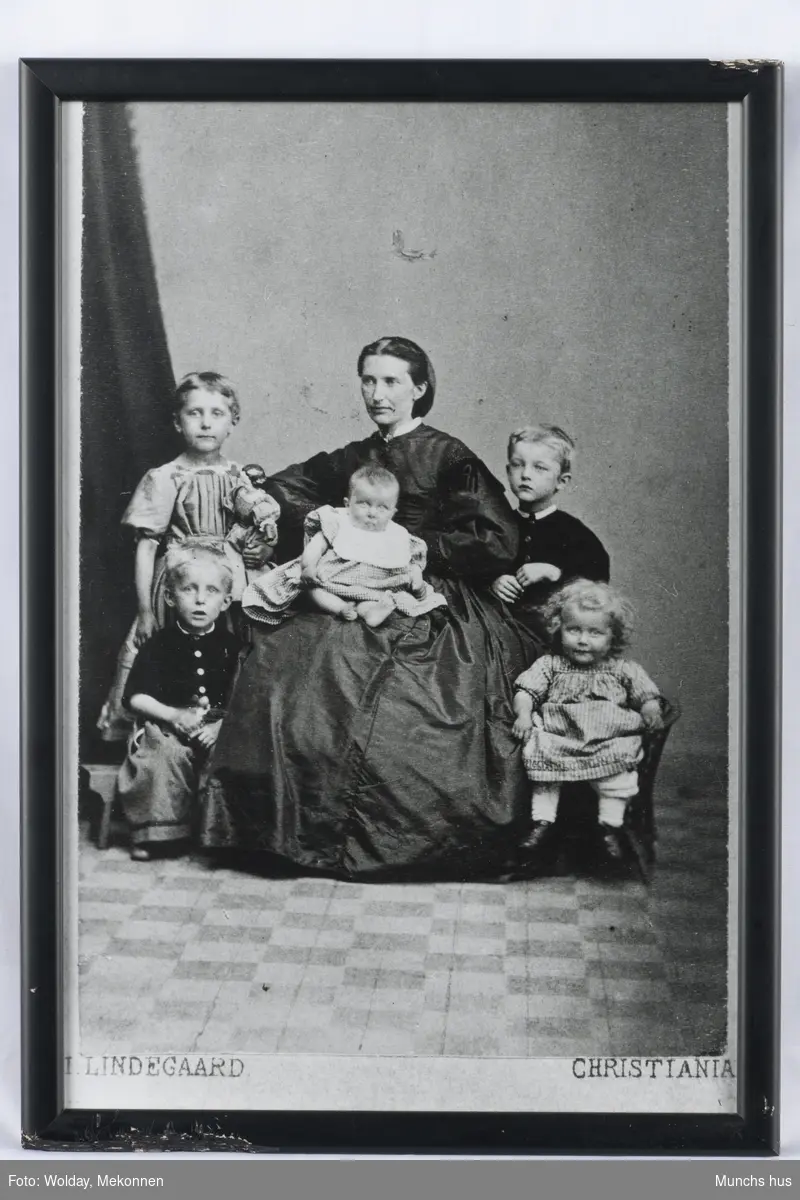 Edvard Munchs mor, med de 5 barna Inger Marie, Johanne Sophie, Peter Andreas, Laura Cathrine og Edvard Munch stående til høyre for moren.

