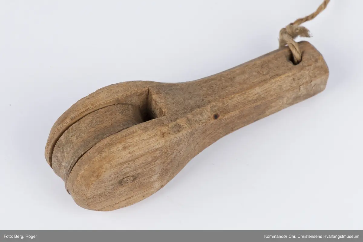 Teknikk: Håndarbeid. Utskåret i pæreform. Hakk inn til trinsehjulene som ble festet v.h.a tre- nagler. Lintråd forbinder de ulike delene
