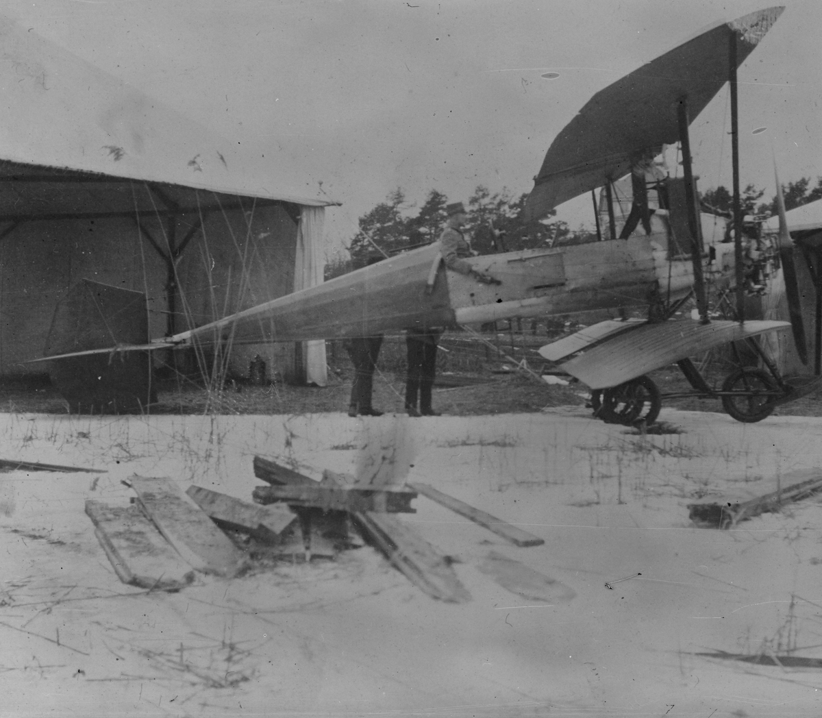 Flygplan B 1 Bréguet C.U 1 sett från sidan vid en hangar vid vinterövning på Lidingö, 1913