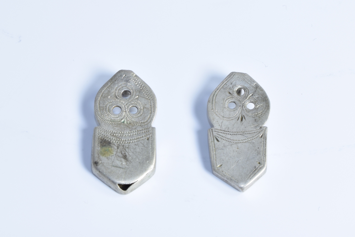 To sproter (beslag på den ene enden av belte til folkedrakt fra Setesdal) av sølv dekorert med siselerte border.