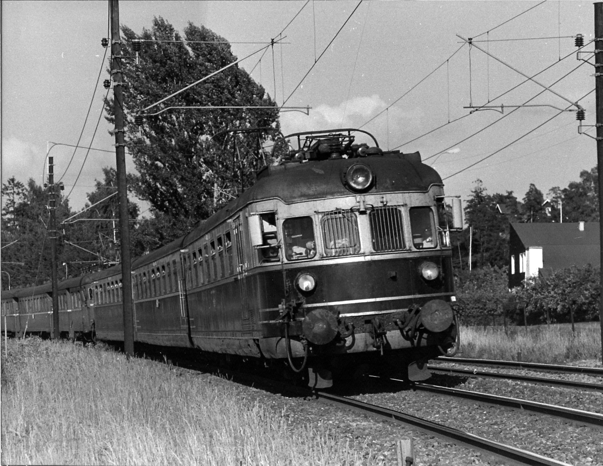 Hurtigtog 811 Oslo V - Larvik med NSB elektrisk ekspresstog type 66 passerer Strand. BM 66 01. Bakerste togsettet, type 68A, ble koblet fra i Drammen og gikk til Vestfossen.