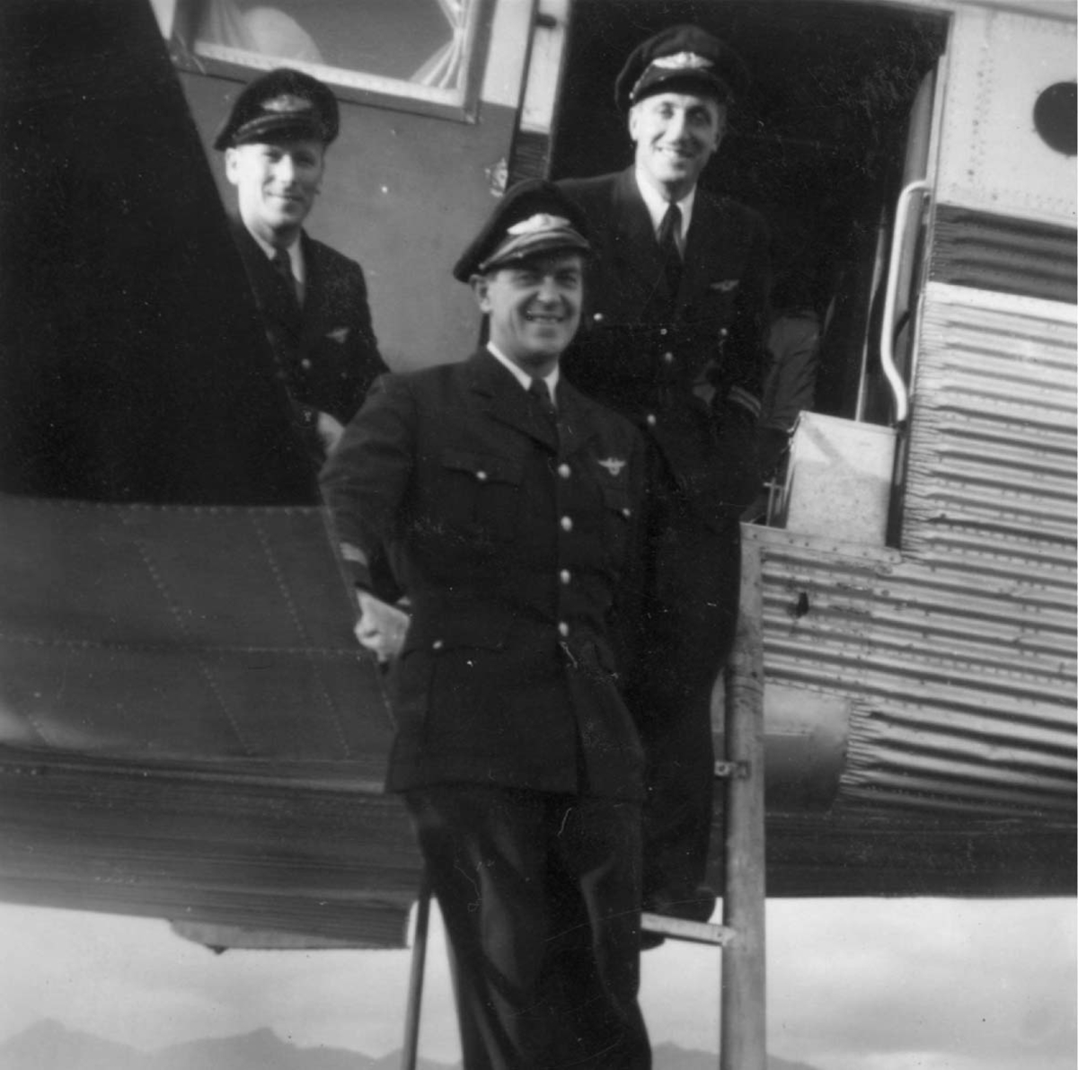 Portrett, tre personer, flymannskap ved innganspartiet til ett fly,  Junkers Ju52.