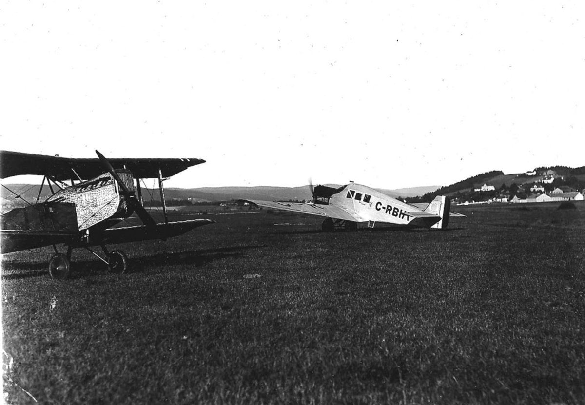 Åpen plass, lufthavn, to fly på bakken,  t.h. Rumensk  Junkers F.13 reg. C-RBIM, Kaje t.v.