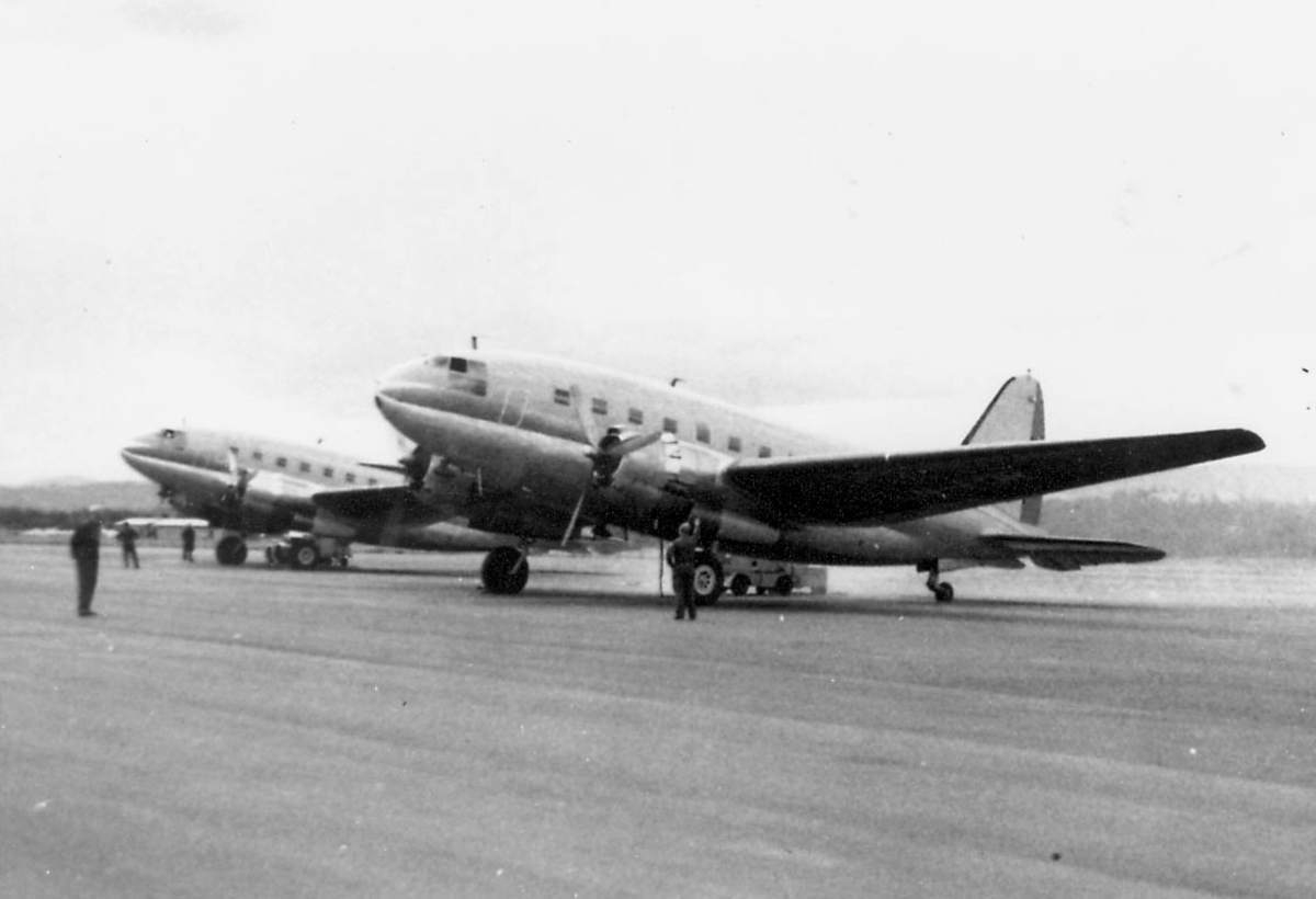 Åpen plass, lufthavn. to av de tre Curtis C-46R på bakken