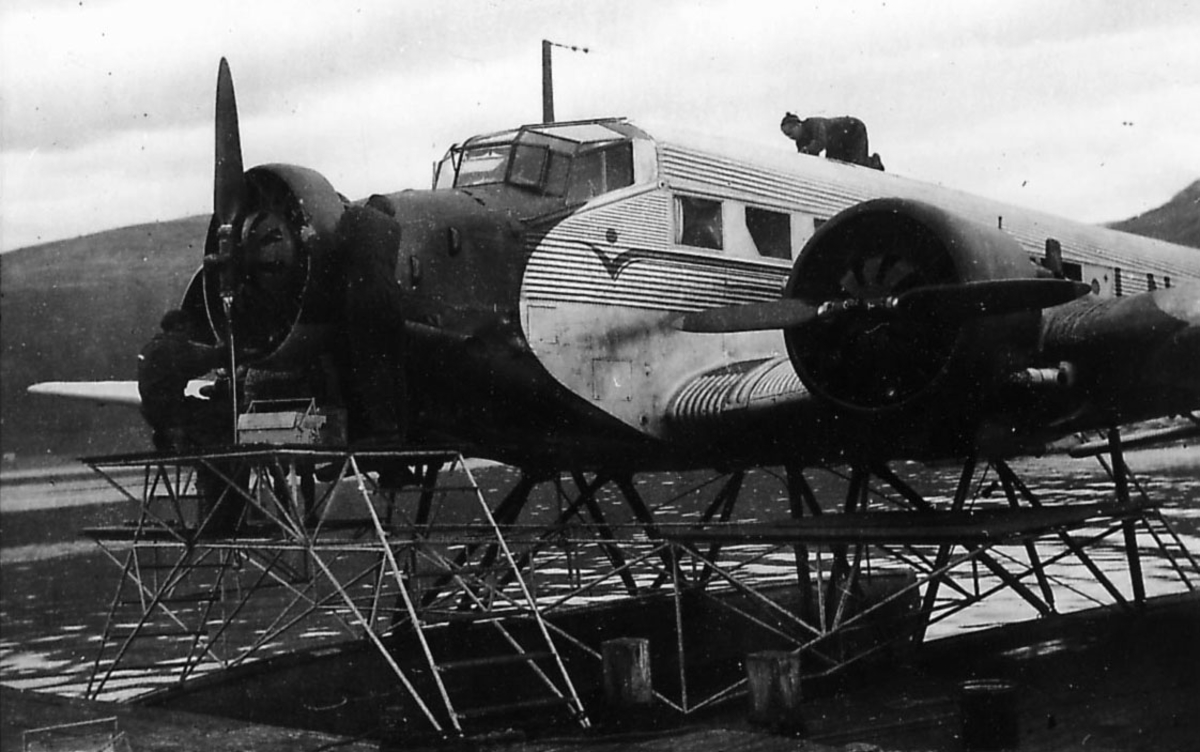Sjøflyhavn, ett fly i vannkanten, ettersyn på Junkers Ju 52/3mg7e. to personer arbeider med flyet.