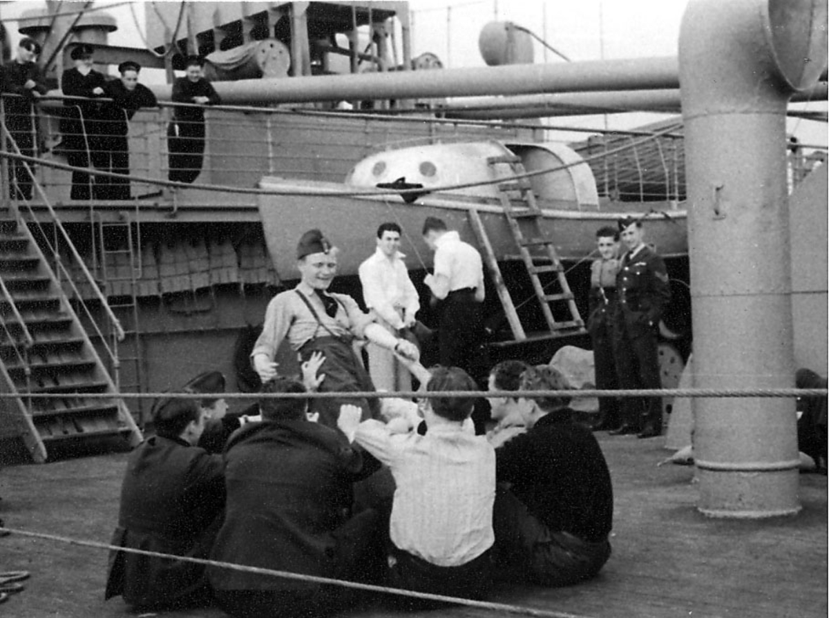 Portrett, en gruppe personer i militæruniform ombord i fartøy.