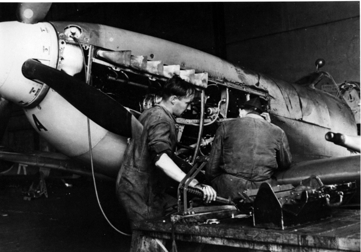 2 mekanikere i arbeid. Vedlikehold - repararasjon av militærfly, Spitfire.