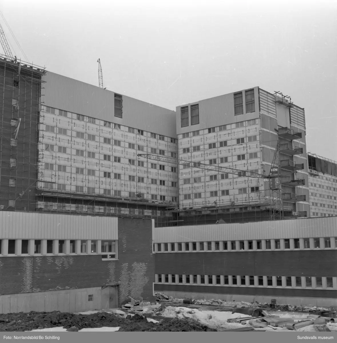 Sjukhusbygget med byggnadsställningar och byggkranar.