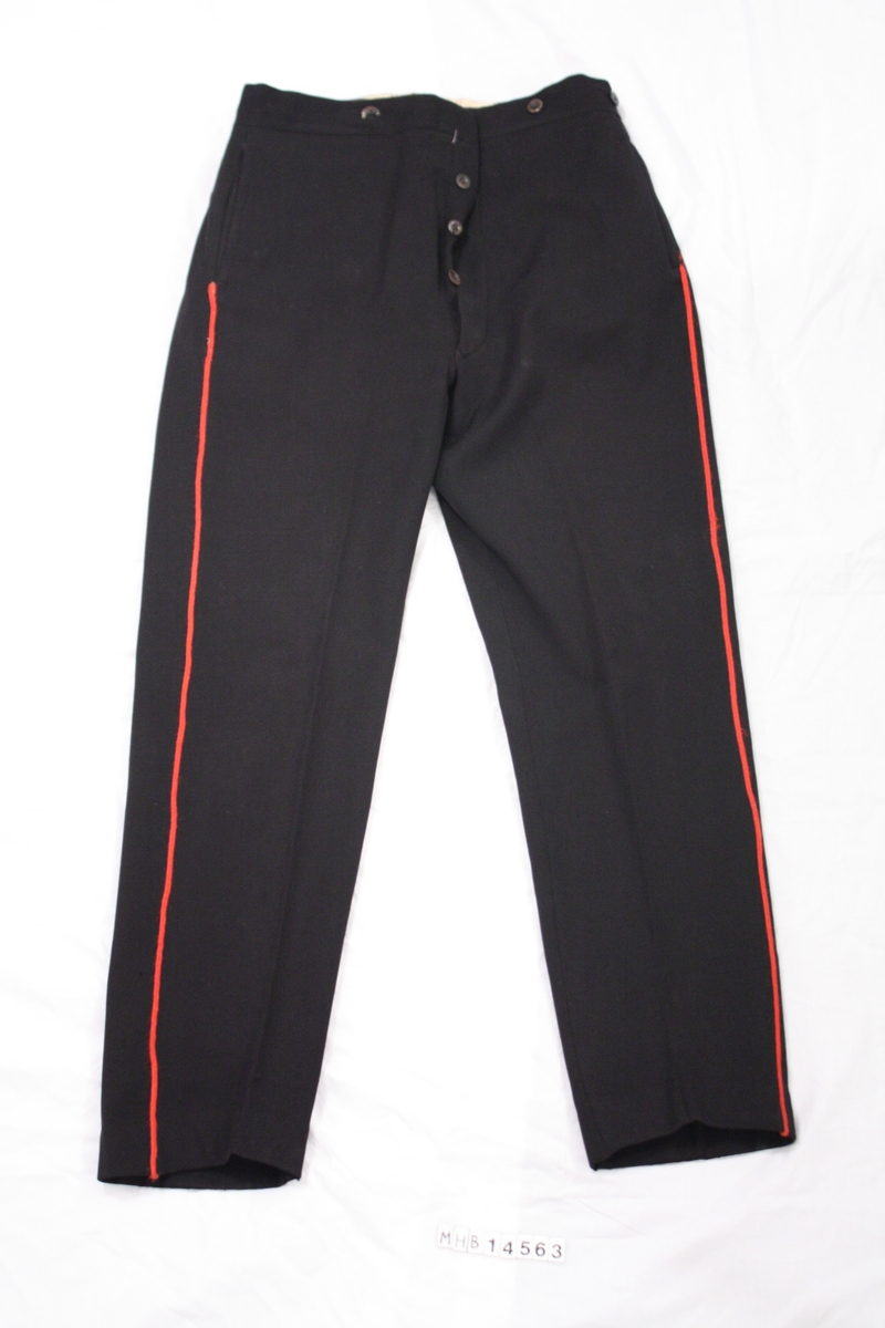 Bukse til brannkonstabel uniform. Sort med rød stripe vertikalt lang buksebeinet. Mulighet til å spenne inn bak på bukselinningen. To lommer på baksiden samt to lommer i siden. Slitefor på innsiden i bukselinning.