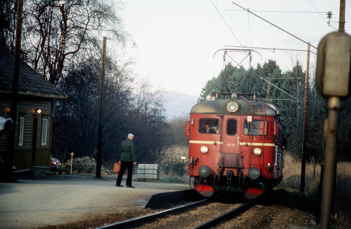 En reisende venter på lokaltoget til Støren på Stavne holdeplass. NSB elektrisk motorvogn BM 65c 49.