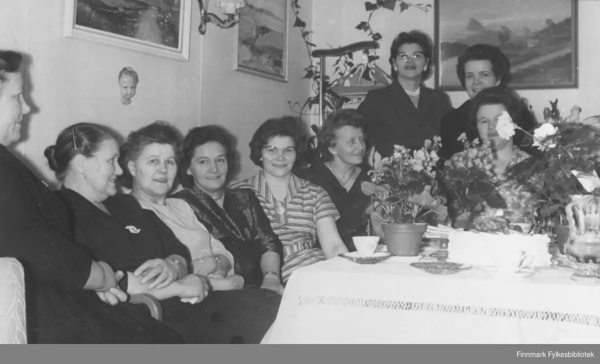 Kaffeselskap i anledning Maud Korvanens fødselsdag, hjemme hos henne på Vadsøya. Fra venstre: Klara Saua, Ester Methi, Maud Korvanen, Astrid Karlsen, Berntine Oldernes, Aslaug Karlsen, Elmine Gulmælæ, Ragnhild Ebeltoft og Johanna Raudajoki