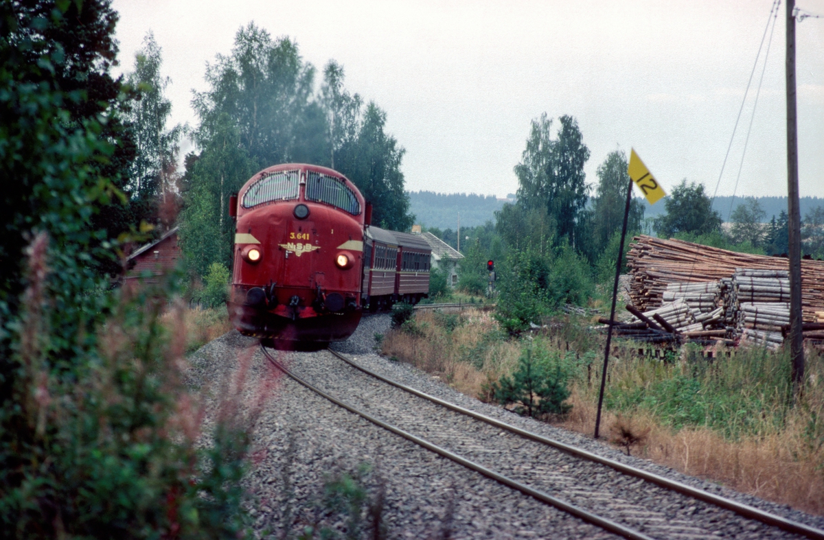 NSBs dagtog, tog 301 Oslo - Trondheim over Røros, kjører ut fra Ilseng stasjon med dieselelektrisk lokomotiv Di3b 641. I bakgrunnen sees enkelt innkjørsignalapparat B på Ilseng stasjon.