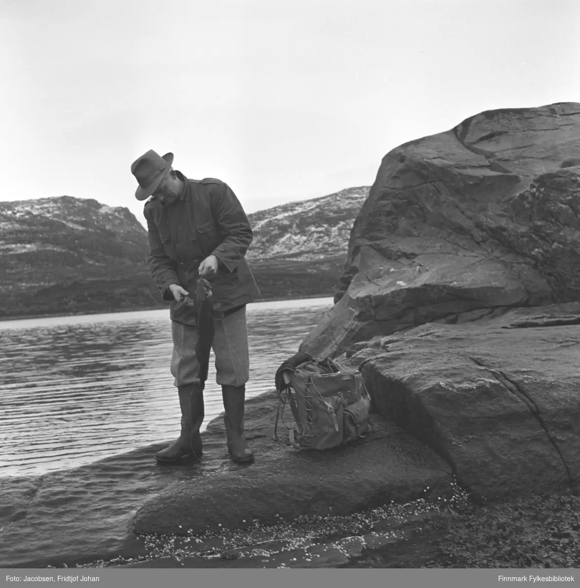 Fridtjof Jacobsen holder opp en fisk som han har fanget