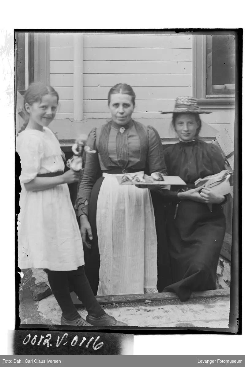 Mor Dahl med sine to døtre fotografert i bakerigården, Steinkjer
