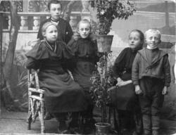 Gruppeportrett av tre jenter og to gutter, tatt i et fotoate