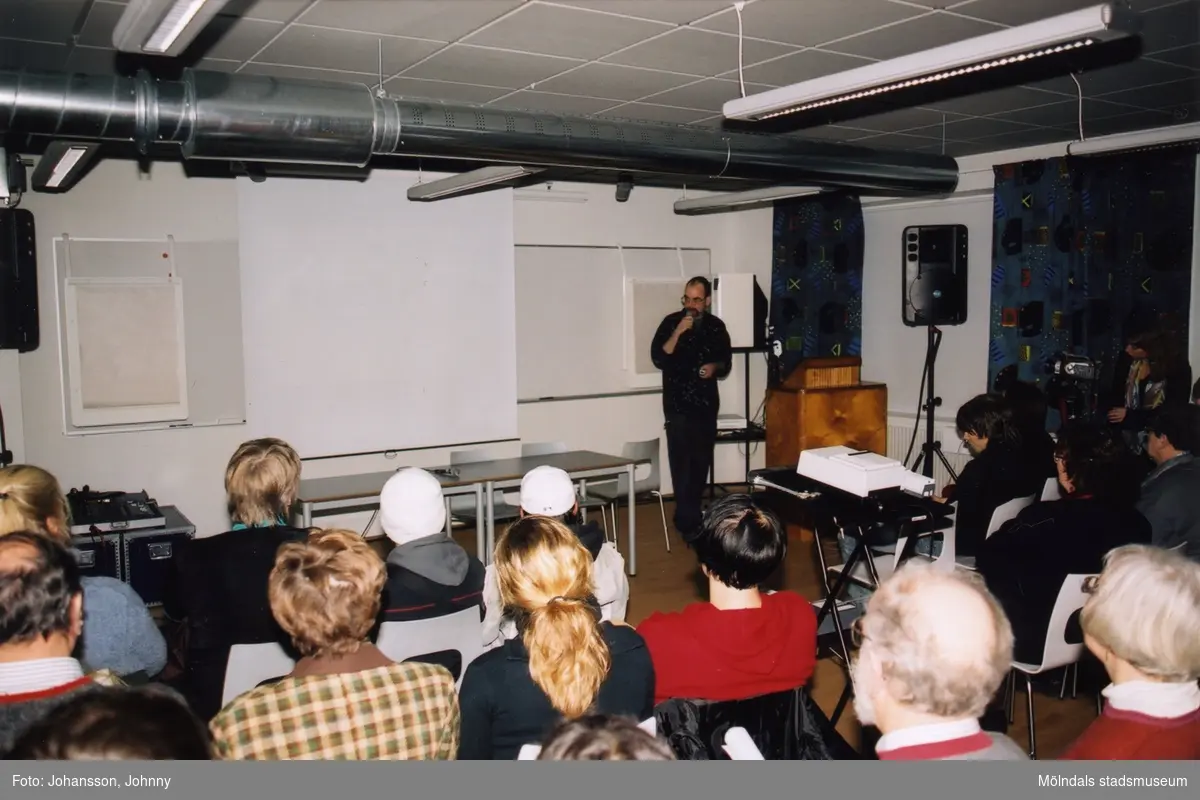 Fil. dr Staffan Jacobsson* håller en föreläsning om graffitikultur i "Stora konferensen" på Mölndals museum, år 2003. I samband med invigningen av graffitiutställningen "Alltså finns jag".
*Författare till avhandlingen "Den spraymålade bilden".