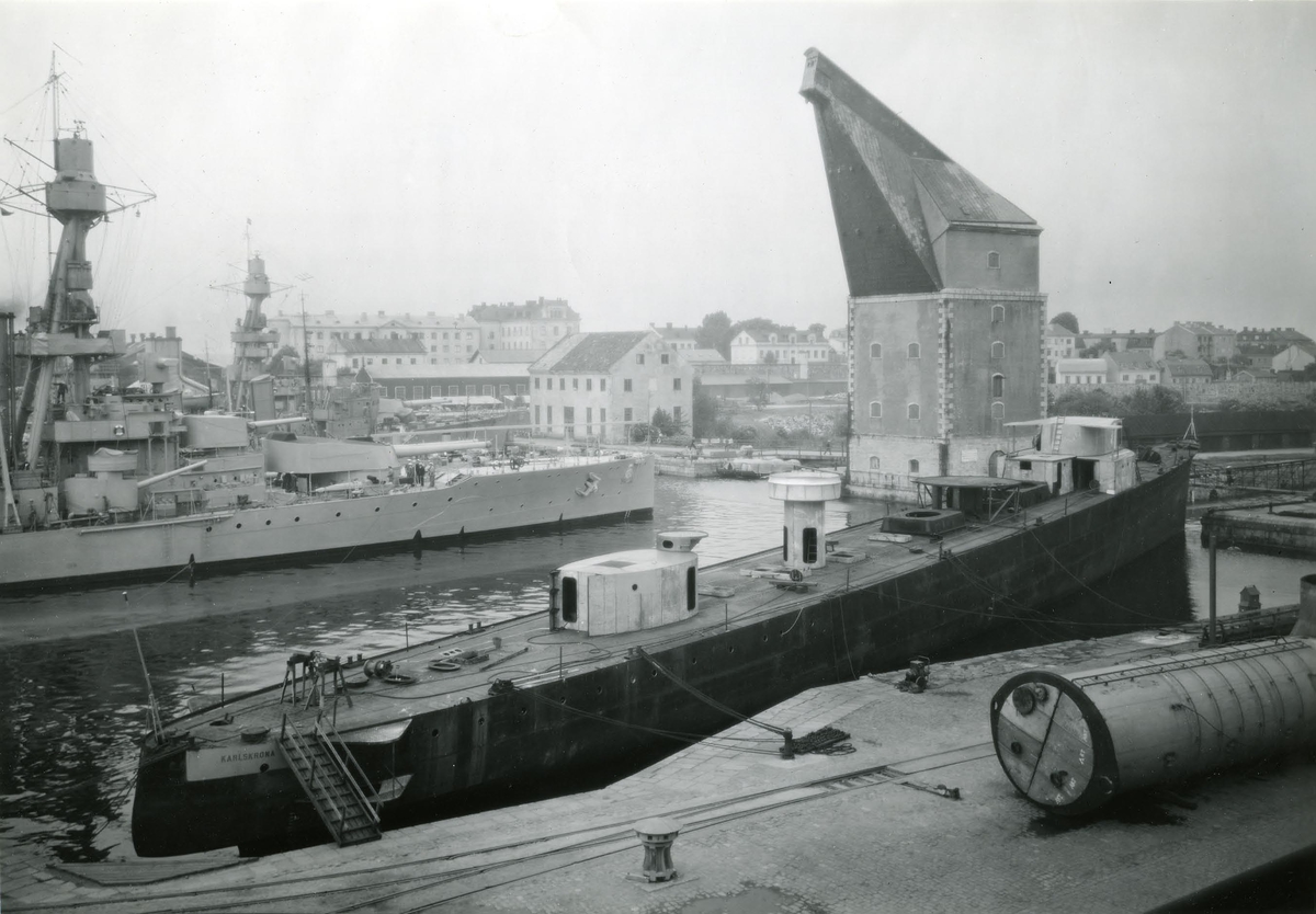 Fregatten Karlskrona under byggnad samt pansarskeppen Drottning Victoria och Gustaf V vid kaj år 1939.