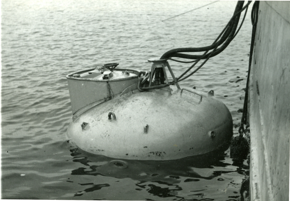 U-båtsklocka i vattnet bredvid bärgningsfartyget Belos.