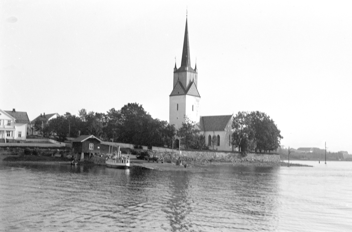 Tingnes, Nes kirke, Hedmark, Mjøsa, Nes brygge. Båten på bilde er "Lettvindt" Mjøsas første propellbåt. (1867). Den ble ombygget flere ganger, og gikk under navnet "Helgøy" og senere "Mira". Bilde ser ut til å være tatt på 1920 tallet da den het "Mira". Den ble hugget på Minnesund i 1960. Mast og ratt befinner seg på Mjøssamlingene.