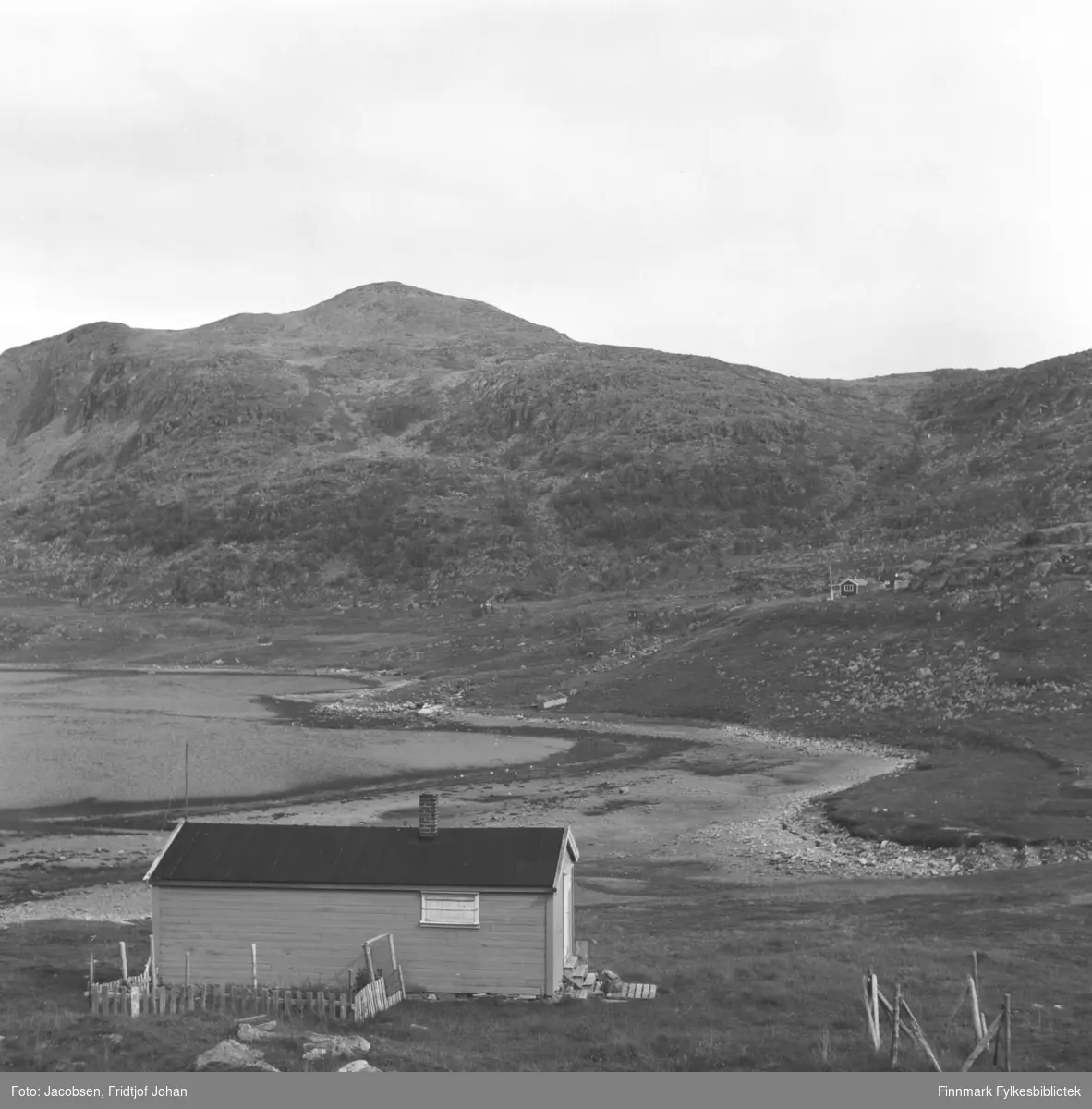 Motiv fra Kvalfjorden like utenfor Hammerfest. Foran på bildet ses Peder Israelsens hytte. Til høyre på bildet, med røstveggen mot kamera står Kåre Nordhus' hytte.