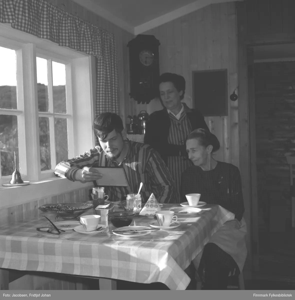 Sigrud Logn fra Oslo spiser frokost hos bestemor Sigrid Nakken i Rypefjord. Tante Aase Jacobsen  står bak dem.