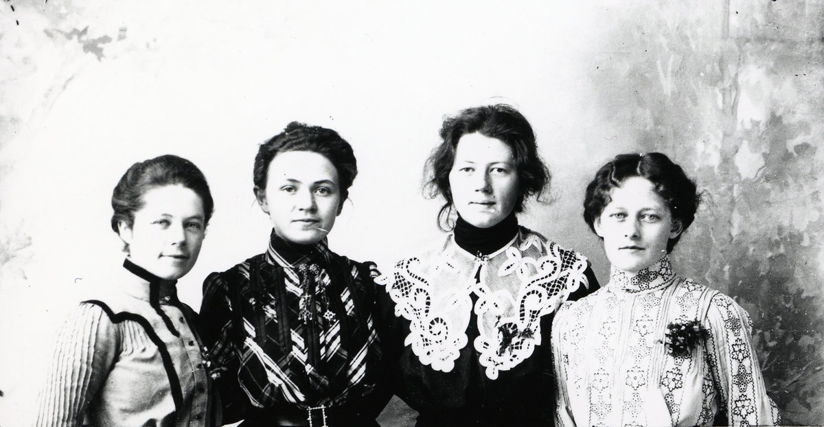 Fire kvinner avbildet foran lerret.