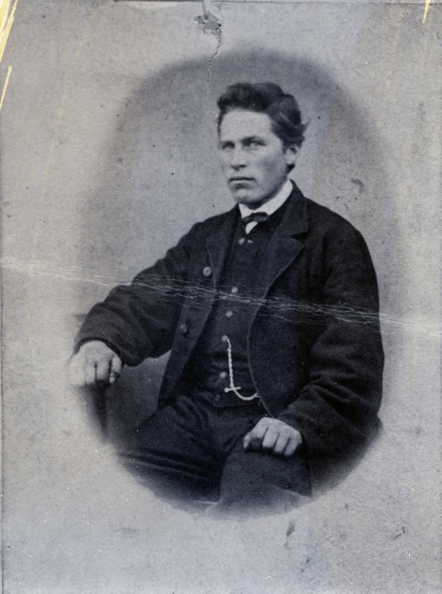 Ung mann avbildet i halvfigur, sittende. Ola Nerby, født på sørre Grøv, Hedalen