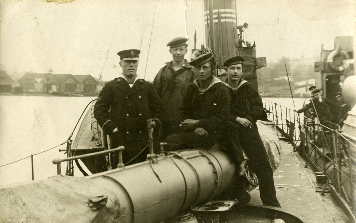 Sjömän i en gruppbild ombord ett fartyg. Gustaf Andersson sittandes på tuben.