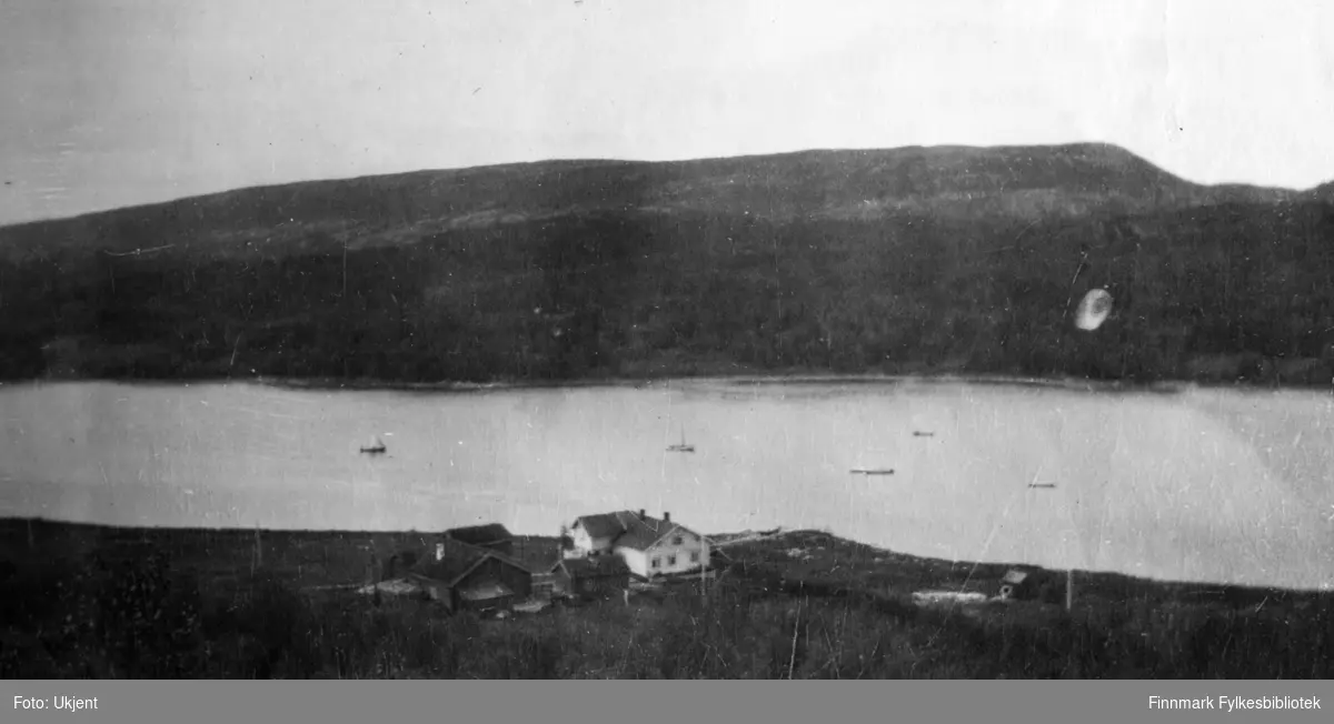 Gården Strømsnes i Jarfjord, bildet tatt fra høyden ovenfor gården sommeren 1923. Man kan se at gården ligger ved havet og enkelte båter ligger ikke langt unna. På huset kan man se vindu og skorstein. Huset er omringet av gjerder.