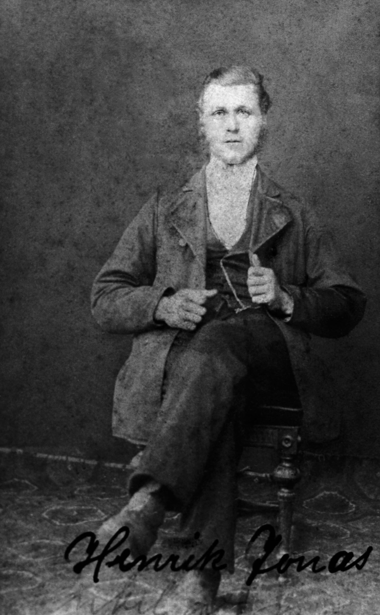 Portrett av en mann, Henrik Jonas. Han sitter på en stol kledd i finstas. Han emigrerte fra Vadsø til USA.
