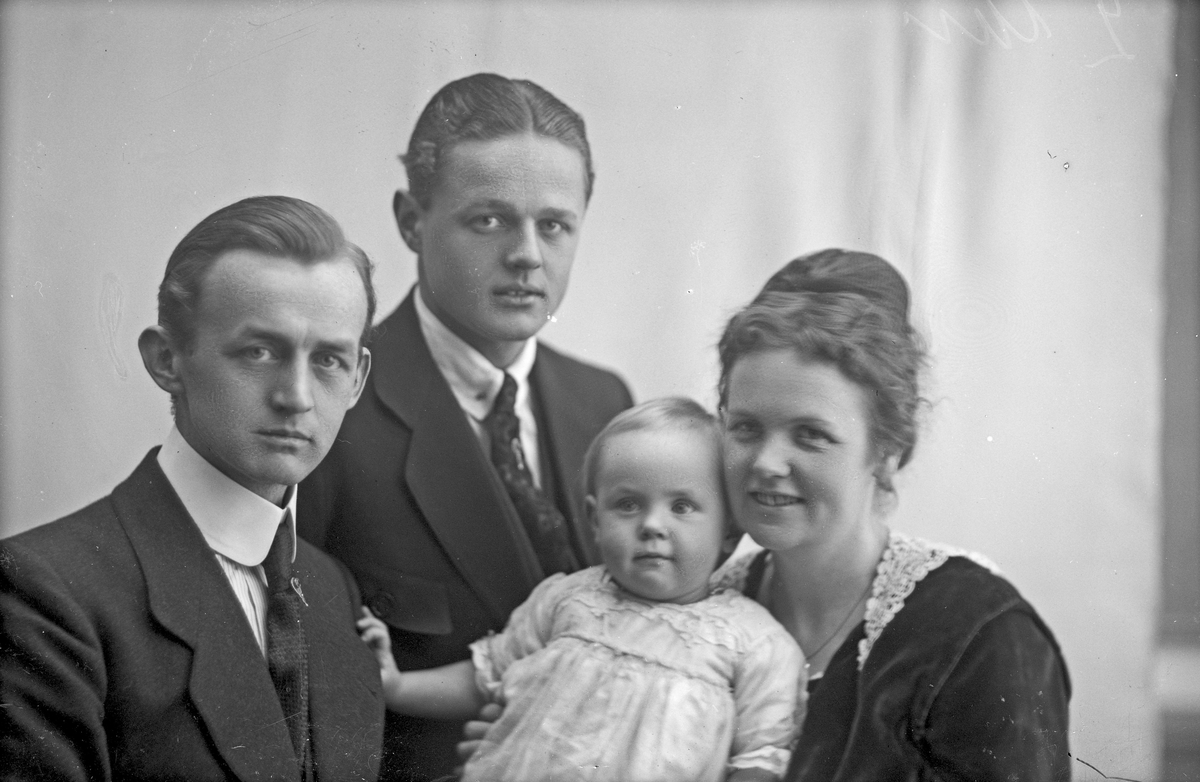 Familiebilde av to unge menn, en ung kvinne og et barn. Bestilt av Arnold Johnstad