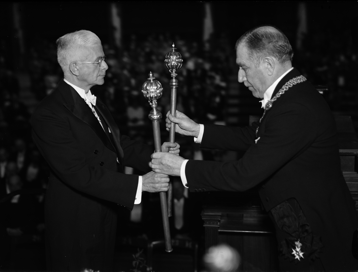 Avgående rektor Thore Engströmer överlämnar Uppsala universitets båda silverspiror till sin efterträdare professor Nils von Hofsten vid rektorsinstallationen, Uppsala 1943