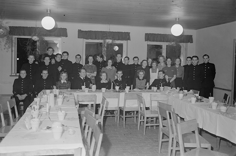Fest för kökspersonal på F 3 Östgöta flygflottilj, 1944. Grupporträtt vid bord.