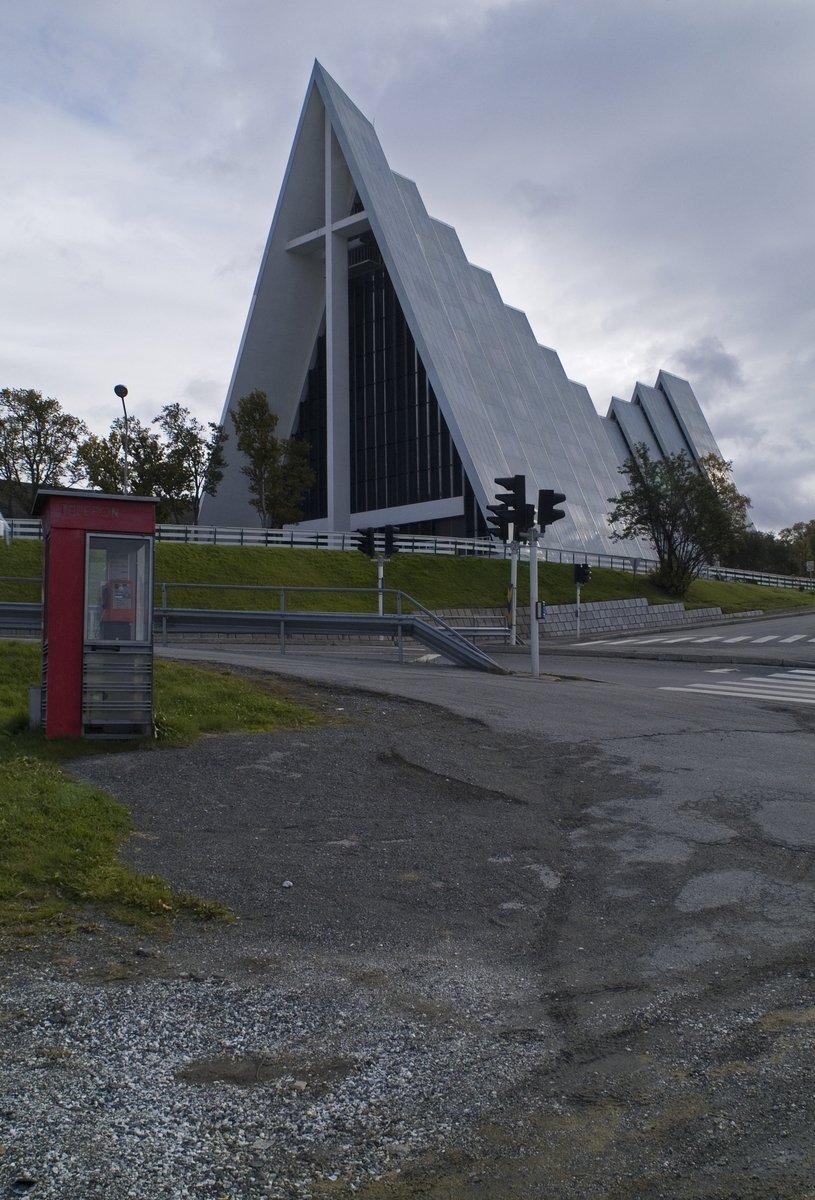 Denne telefonkiosken står ved Ishavskatedralen i Tromsø, og er en av de 100 vernede telefonkioskene i Norge. De røde telefonkioskene ble laget av hovedverkstedet til Telenor (Telegrafverket, Televerket). Målene er så å si uforandret. 
Vi har dessverre ikke hatt kapasitet til å gjøre grundige mål av hver enkelt kiosk som er vernet. 
Blant annet er vekten og høyden på døra endret fra tegningene til hovedverkstedet fra 1933.
Målene fra 1933 var:
Høyde 2500 mm + sokkel på ca 70 mm
Grunnflate 1000x1000 mm.
Vekt 850 kg.
Mange av oss har minner knyttet til den lille røde bygningen. Historien om telefonkiosken er på mange måter historien om oss.  Derfor ble 100 av de røde telefonkioskene rundt om i landet vernet i 1997. Dette er en av dem.