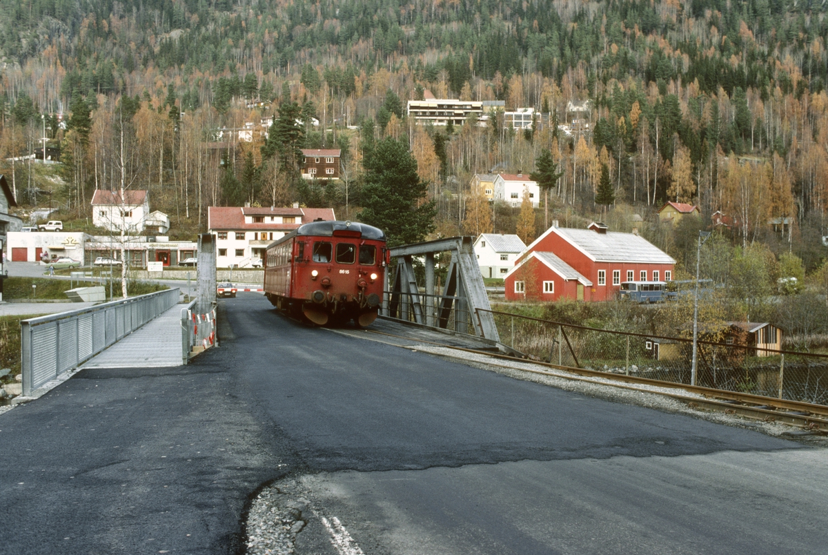 Tog til Kongsberg kjører ut fra Rødberg over felles bro med vei. NSB dieselmotorvogn BM 86k 15 skal bringe de reisende nedover Numedal.