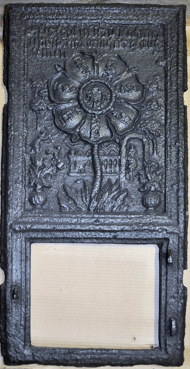 Fra protokollen (R. Berge):
Omn i ei høgd (botnplate vantar) med støypemynster i barok. Bakplata hev øvst denne innskrifti: "Alles thut in Jesu Nahm" "und so reths(?) drauf ein glaube Amen". 
Under denne ein stor sjaubladd blom, i kvart krunblad ordet: IESVS, i blomcentrum bokstavane A.M.E.N. Under blomen ymse motiv. Under desse att innskrifti: "Jesu beistand in der (Arbeit Jeder tag sein) Arbeit hat die uns mühel(?) früh und spät soll sie men von statten(?) gehen So müss Jesus bei dir stehen."
ST Anno (Jahr)  MT 1668 (Aarst. utydelegt).
Framstamnen som bakstamnen, men vantar alt som er nedanfor blomen.
Langsidune hev eit stort landskap, med ein islagd kanal(?), der ein mann gjeng paa (is)styltrur; han hev mist den eine og held paa aa dette i koll. Bak honom paa isen ser ein folk skuvar kvarandre paa kjolke. Bak kanalen landskap. Ikring bilætet er ei raame av baroksveivar. Yvi raama er ei innskrift, som luar: "Wer will närsisch(?) grösser sein Schadt ihm (je?) ... legt umehr ein."
Under bilætet au tysk innskrift, men støypingi er paa baae platune so utydeleg at ein fær kje samanheng i ho. 
Hyrneskinune vantar.