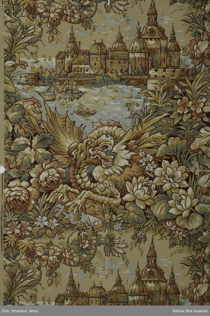 KLM 21065. Tapet. Tittskåpstapet. Av papper. Motiv av Kalmar slott, en drake och stora blommor. Färgerna är mustiga i blått grönt, gult, guld och djup rosa. Tapeten är handtryckt. Datering: 1890-tal.
