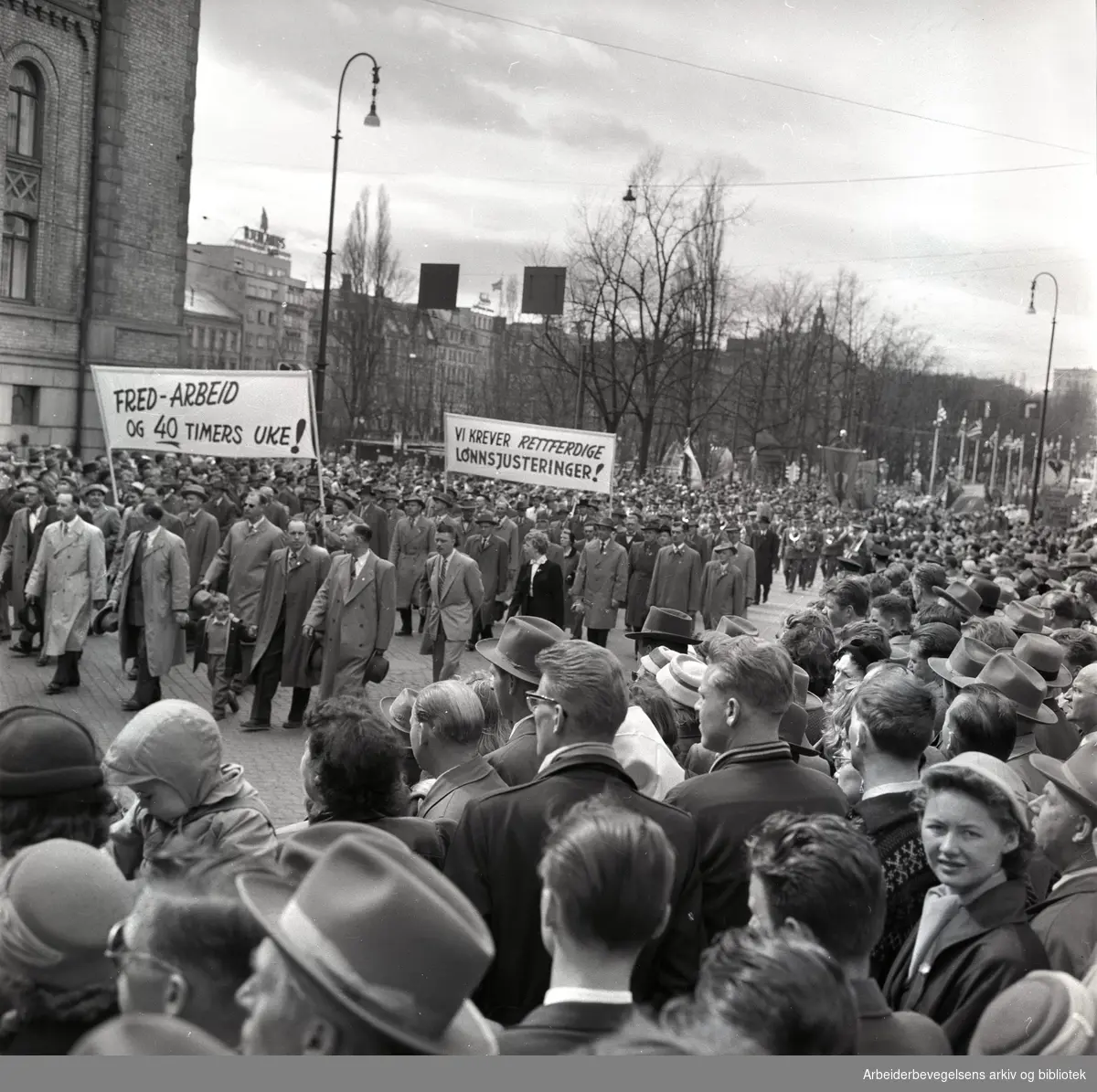 1. mai 1958 i Oslo.Demonstrasjonstoget på Karl Johans gate.Parole: Fred - arbeid og 40-timers uke!.Parole: Vi krever rettferdige lønnsjusteringer